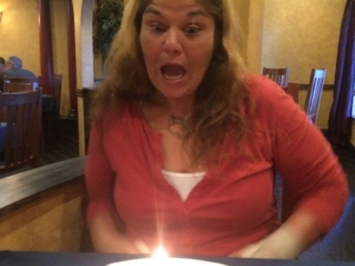 Woman blowing out birthday candle